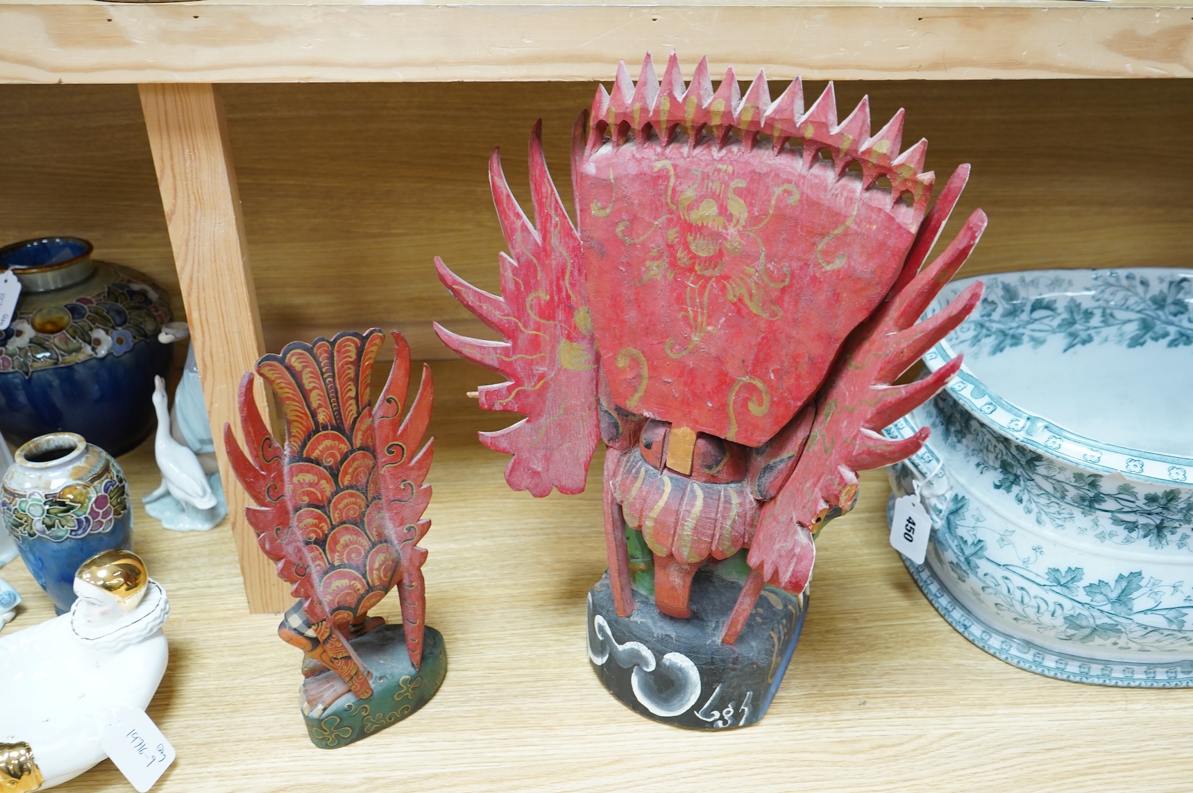 A Balinese painted and carved wood sculpture of Garuda, together with a smaller similar carving, largest 46cm high